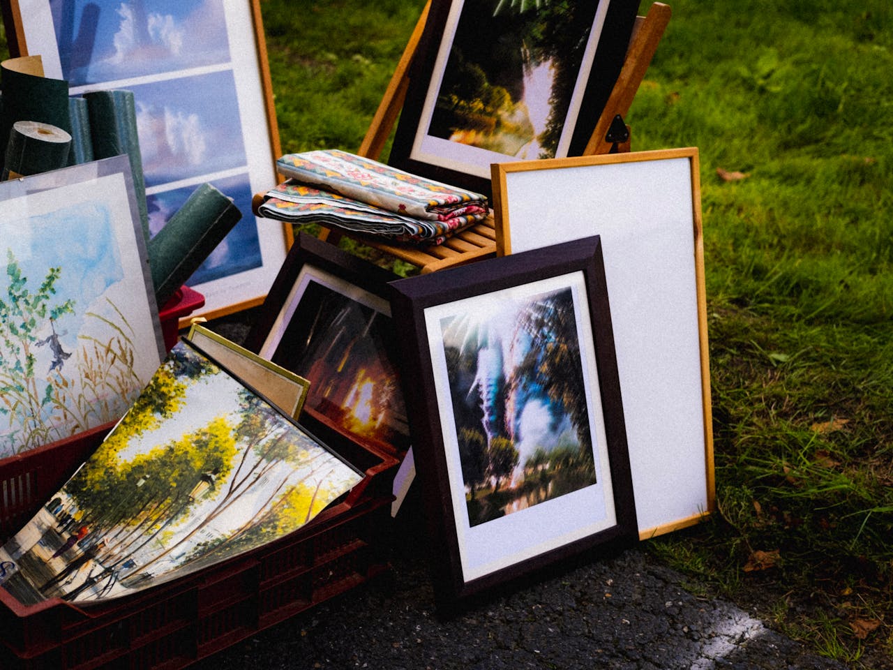 services-01 Various framed artworks displayed on grass, creating an outdoor art gallery vibe.