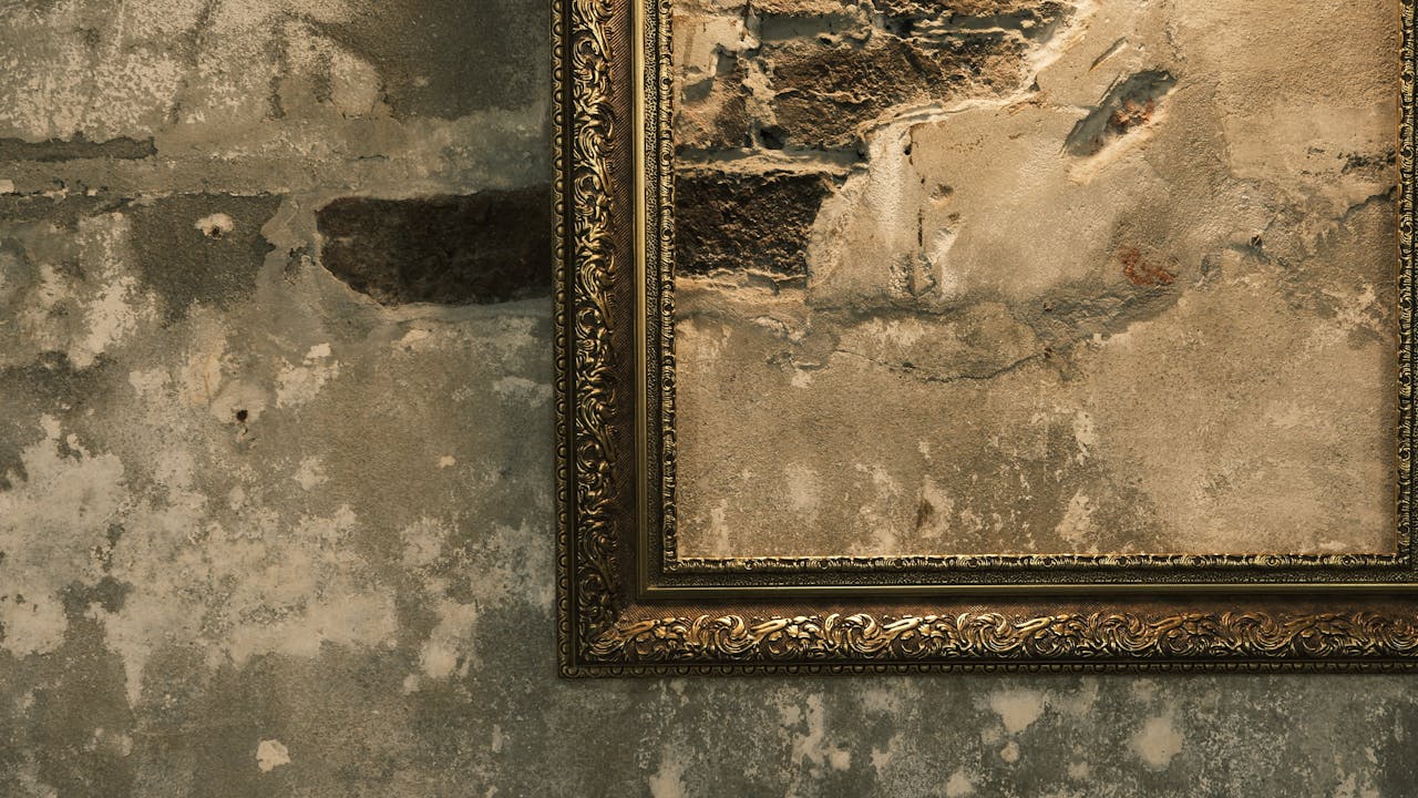 gallery-6 A detailed view of a vintage ornate frame against a textured rustic wall.