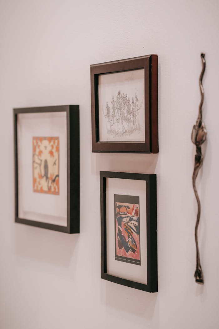 why-choose-us Collection of pictures in rectangular shaped wooden frames near decoration on white wall in house room