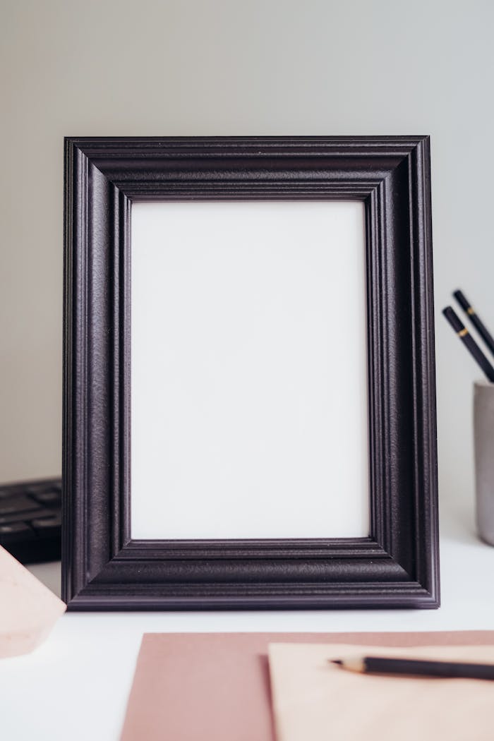 services-02 A stylish black picture frame placed on a minimalist desk setup with soft lighting.