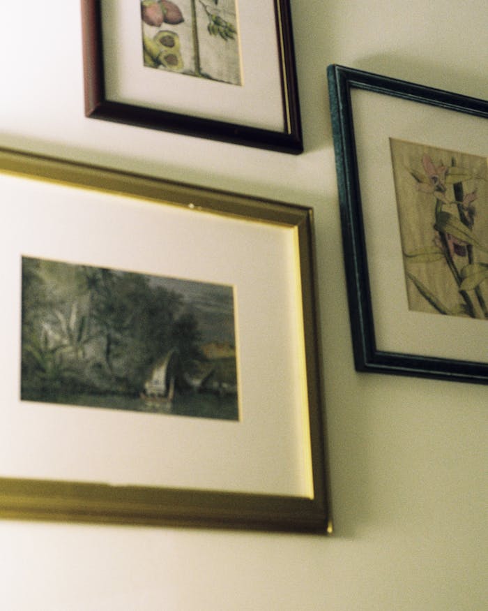 about-01 Collection of framed artwork displayed on a wall, showcasing elegant interior decor.